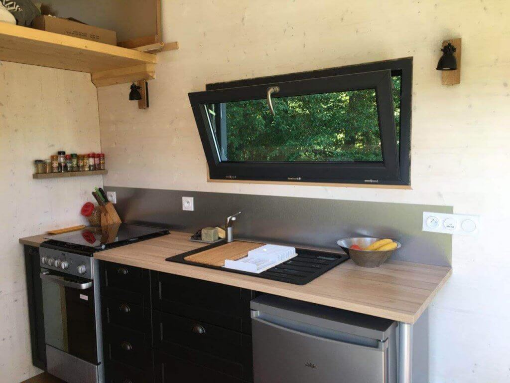 cuisine de tiny house avec plan de travail et fenêtre ouverte